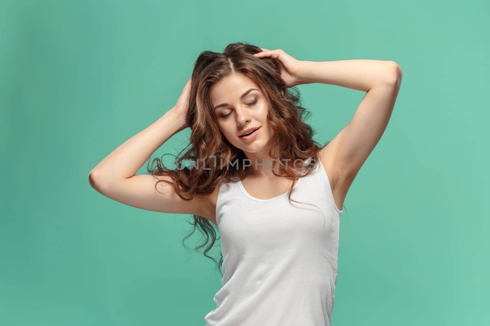 The young woman's portrait with happy emotions on blue background