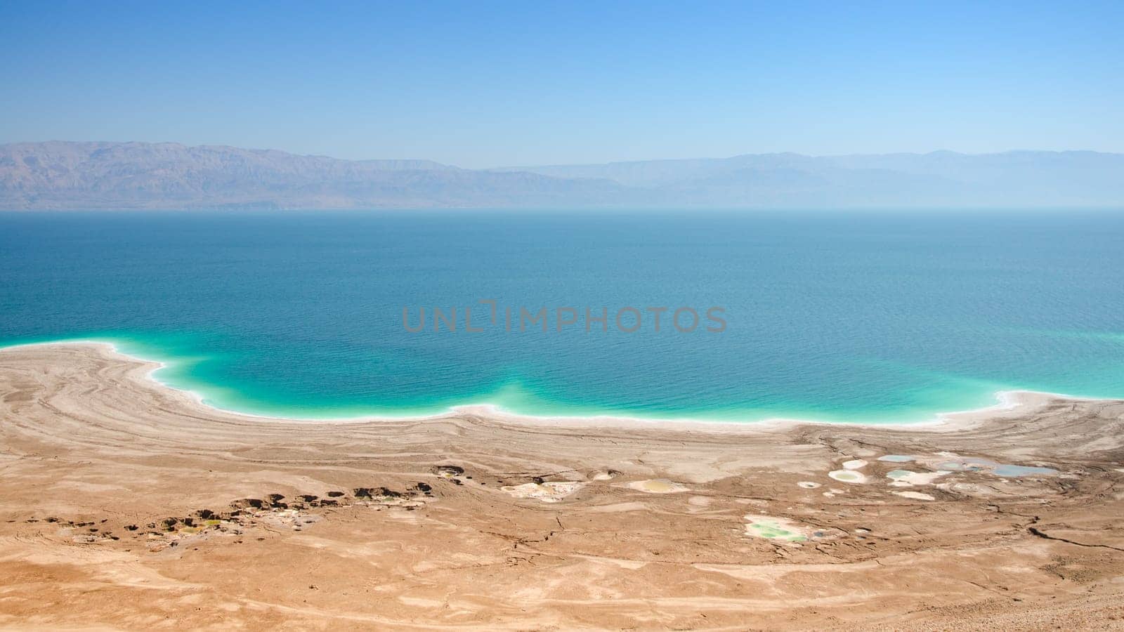Aerial panoramic landscape of Dead Sea lake with salt water and curative mud shores beaches