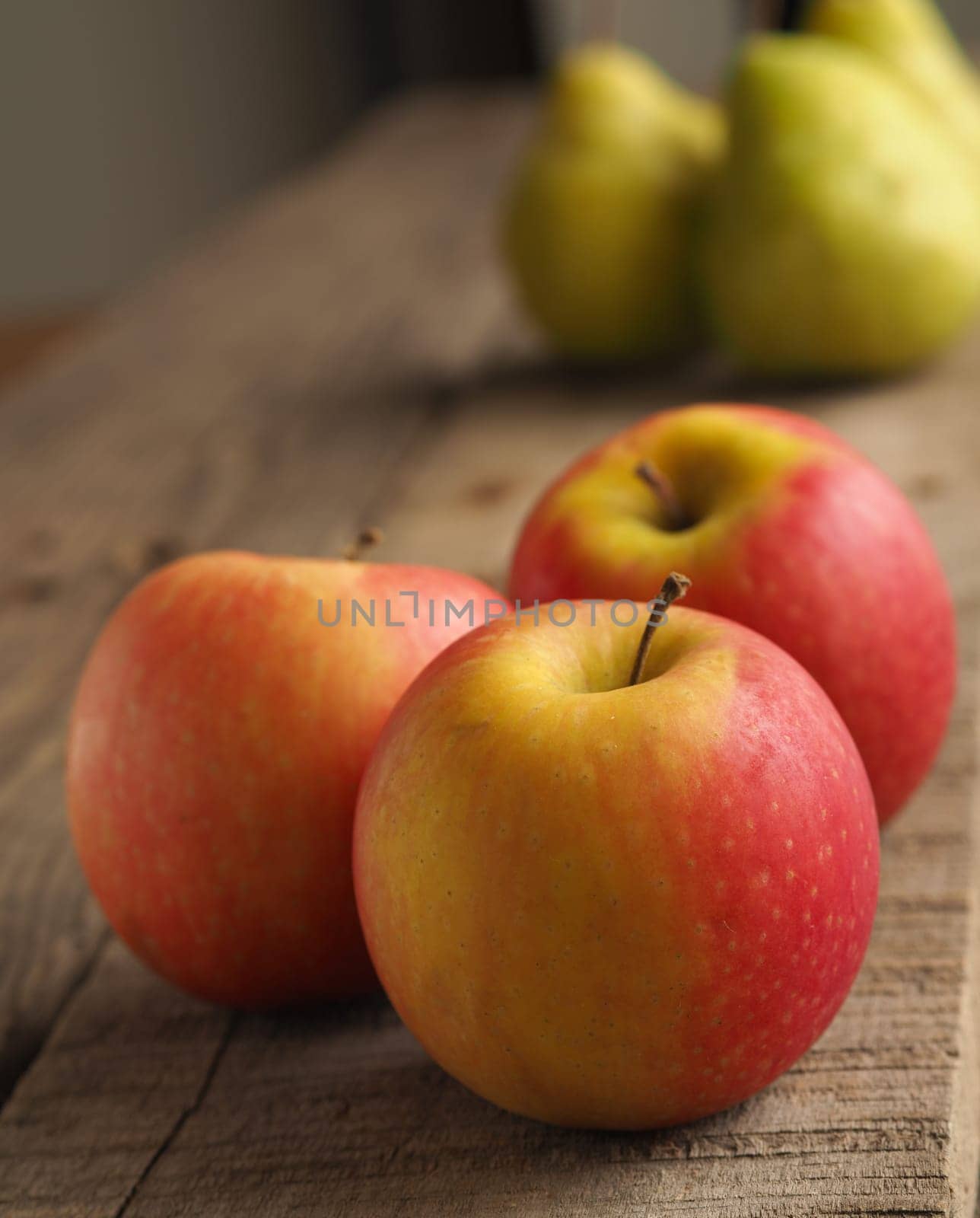 Red apples and gree pears on a rustic wooden table