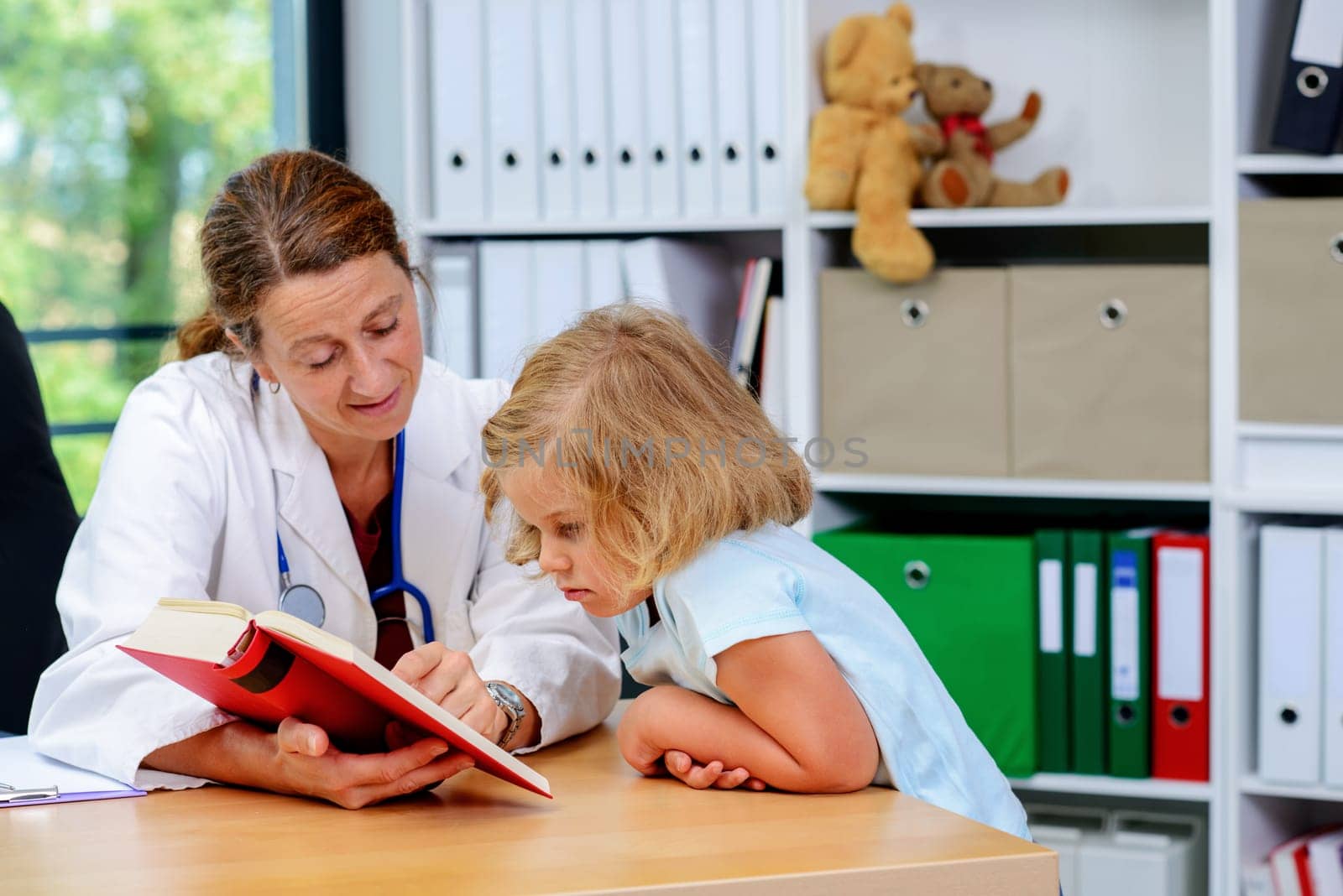 female pediatrician in white lab coat and the little patient