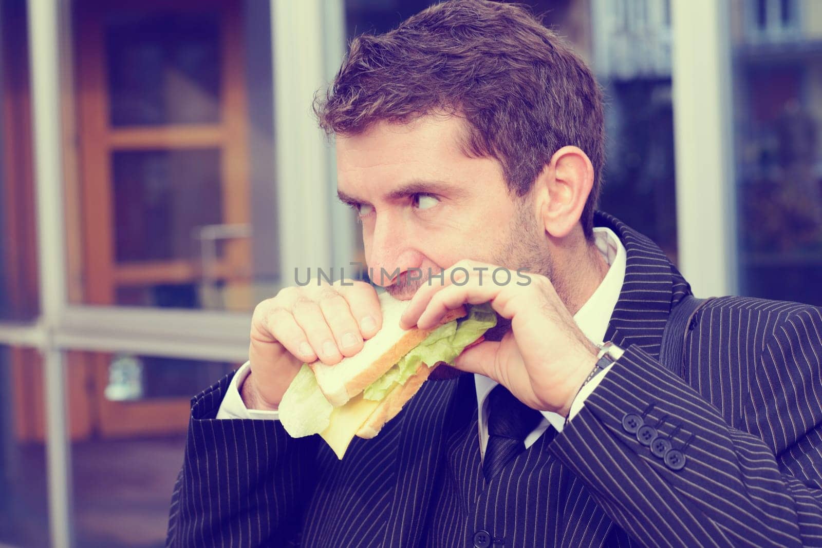 businessman in suit in front of city- background is eating