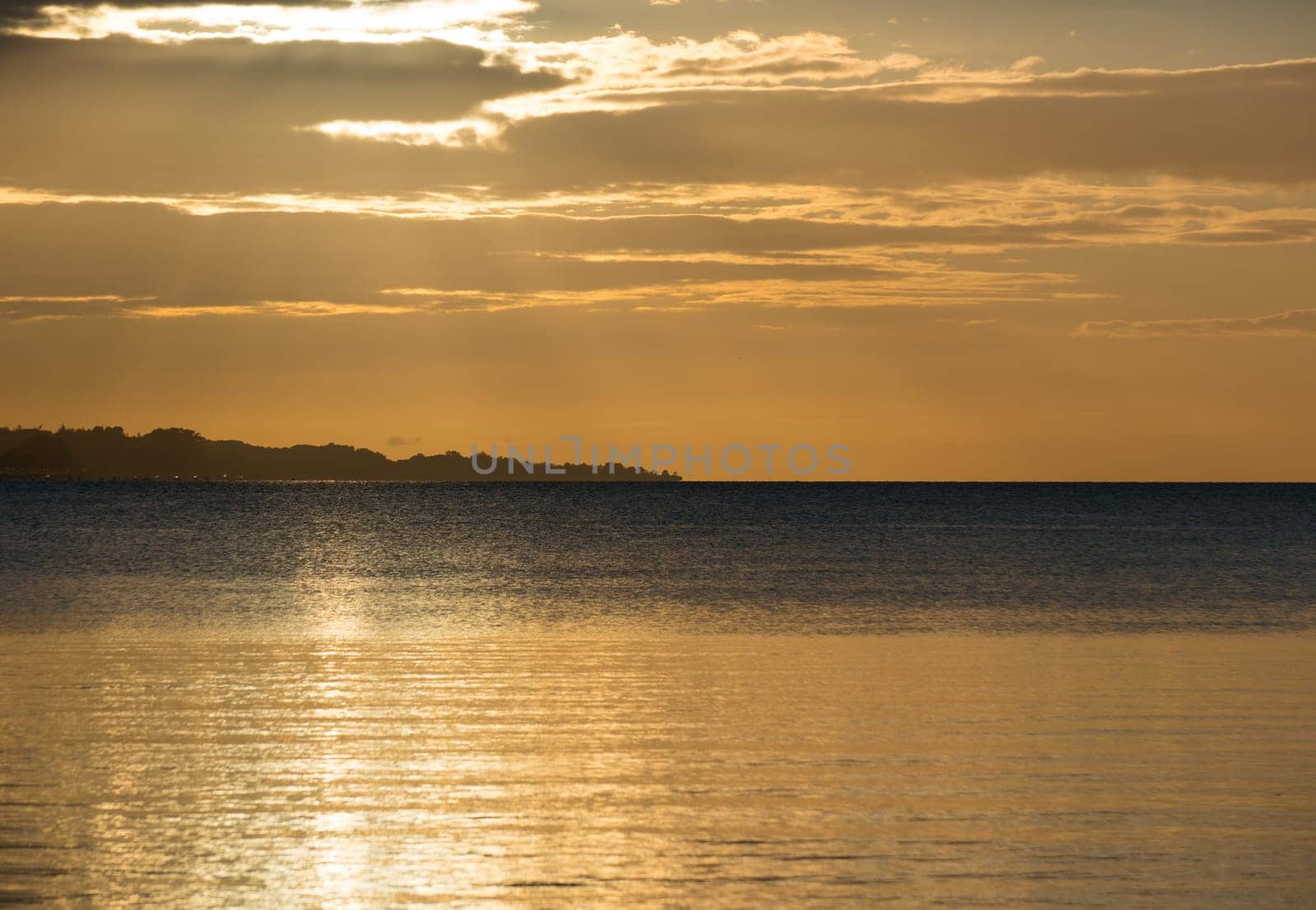 Beautiful sunrise in the summer over silent glossy sea And clouds in the sky . Panorama