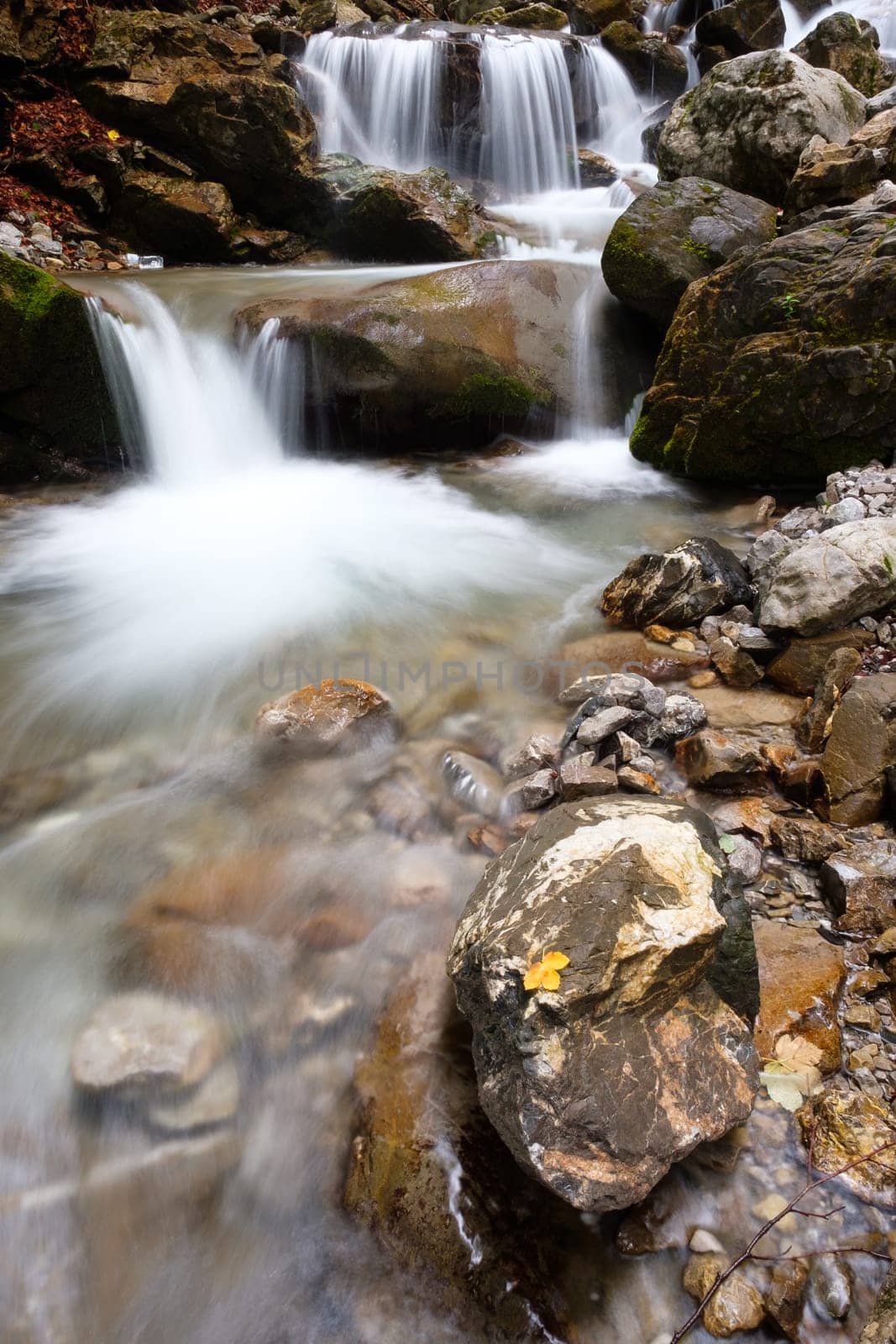 Waterfall in the water Faltenbach in Oberstdorf with rocks and leaf