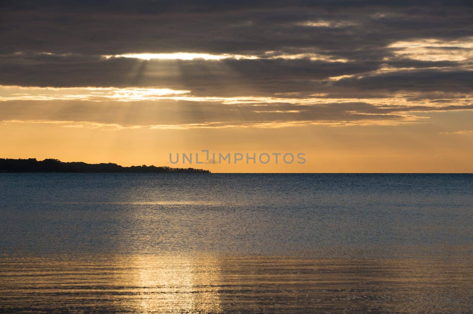 Beautiful sunrise in the summer over silent glossy sea And clouds in the sky . Panorama