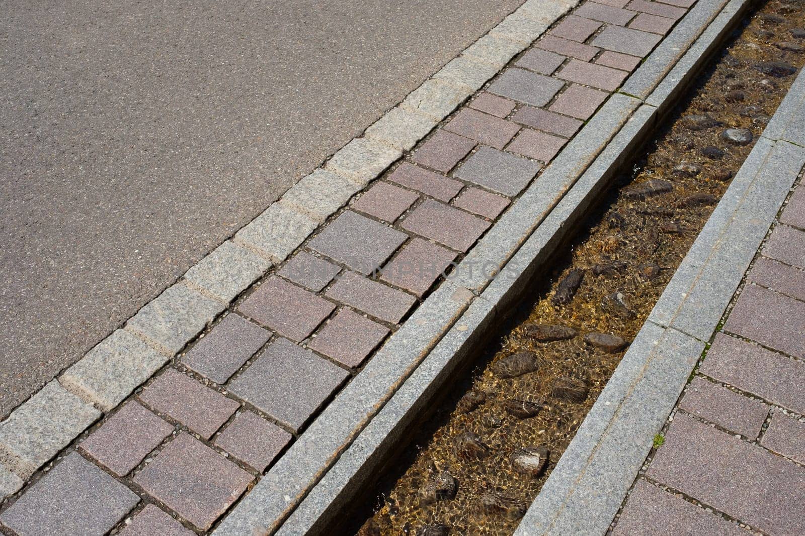 Stone canal with water between pavement and street - Infrastructure