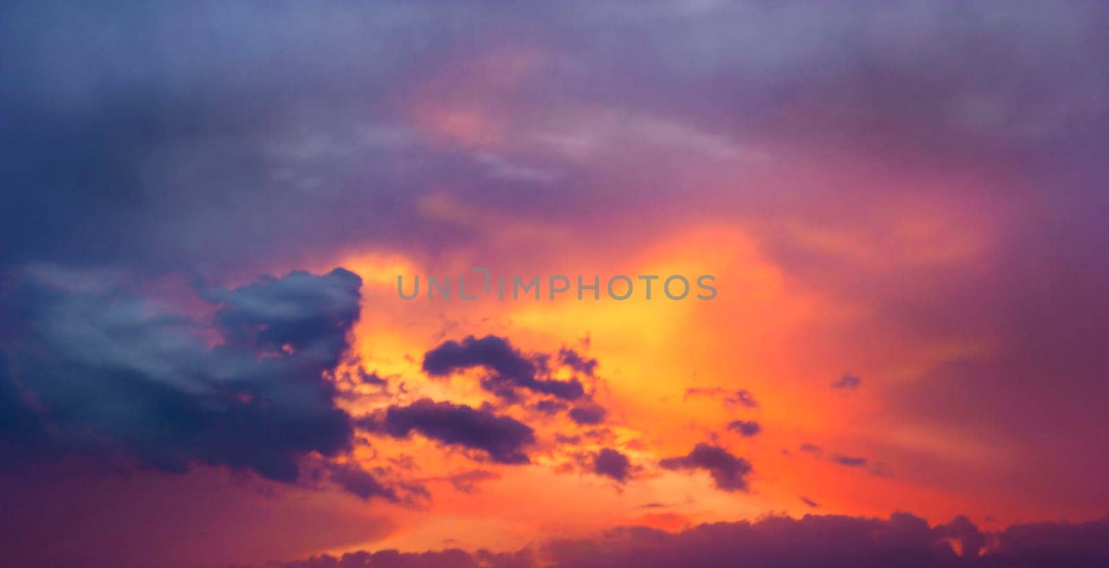 Sunset amid thunderclouds. Sunset shines red through dark clouds.