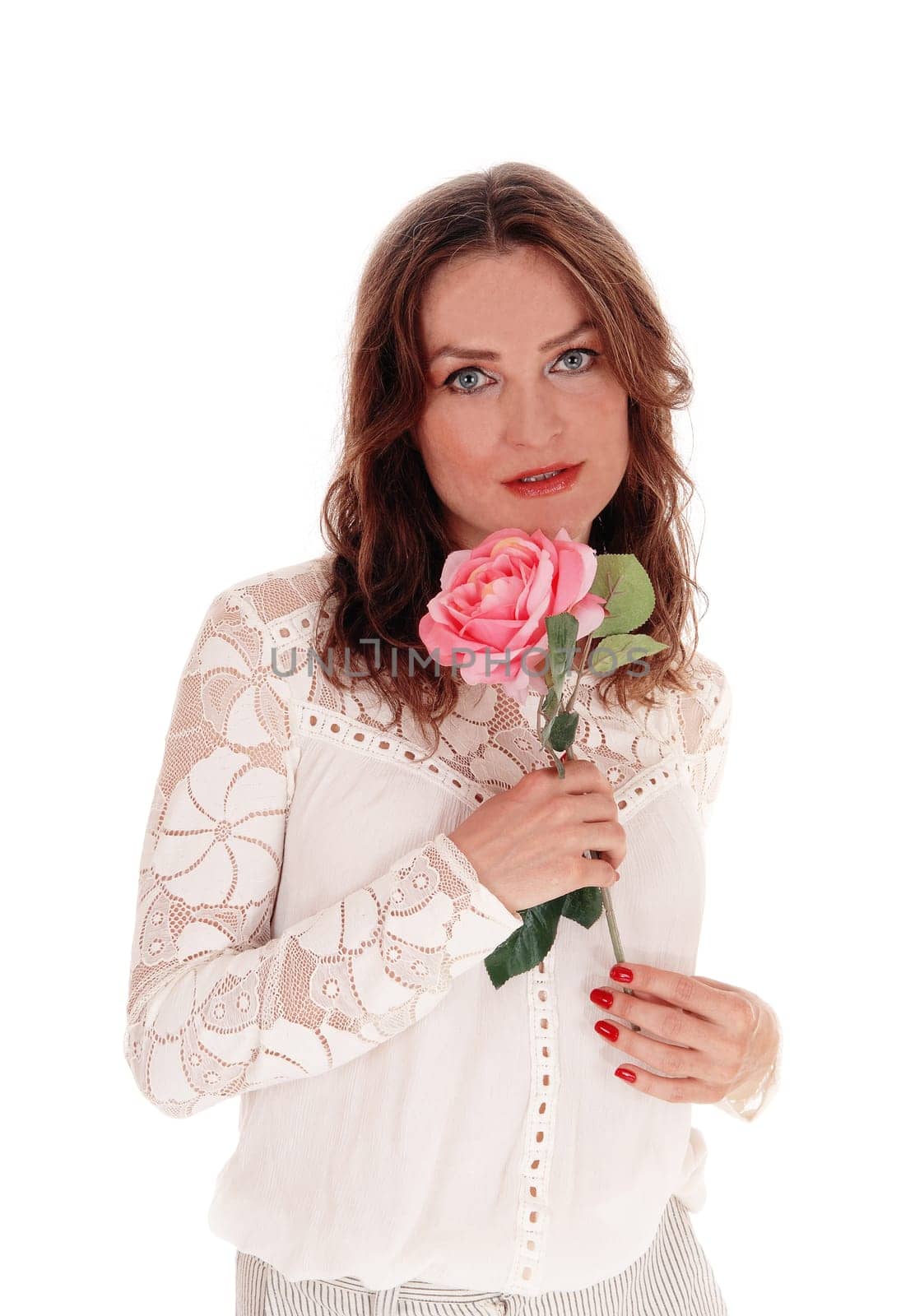 A beautiful young Caucasian woman in a lace blouse and brunette hair.holding a pink rose in her hand, isolated for white background..