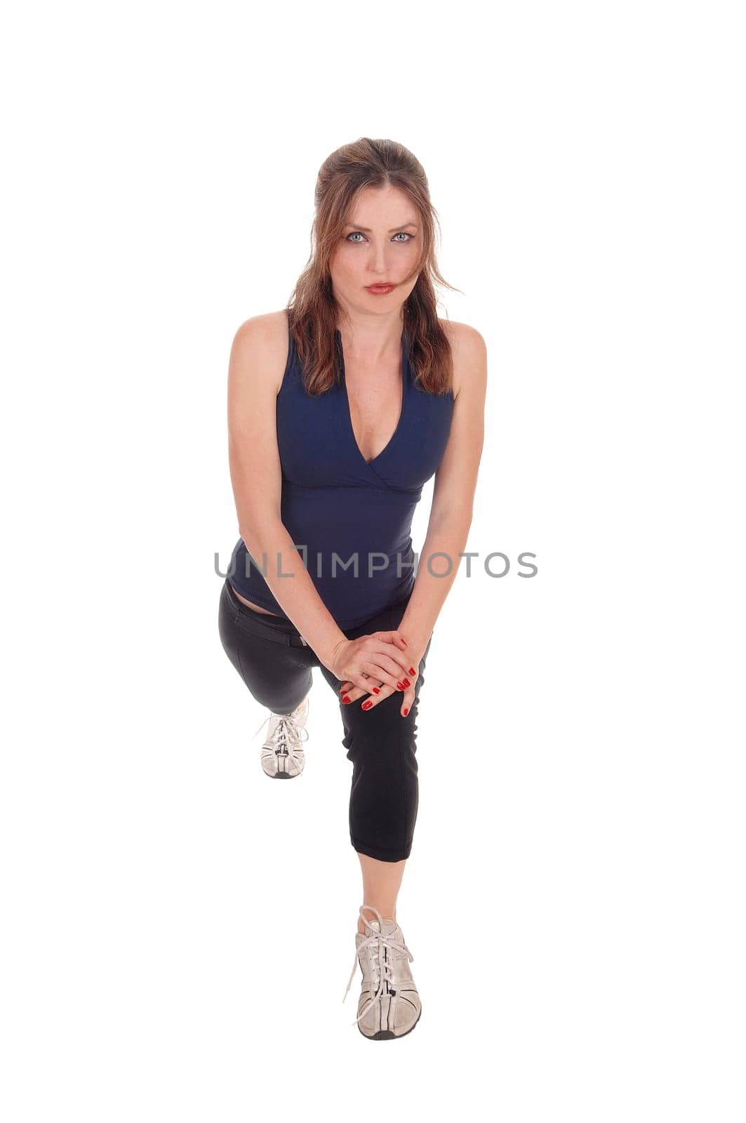 A beautiful woman in exercising outfits stretching her legs after some.exercising, isolated for white background..