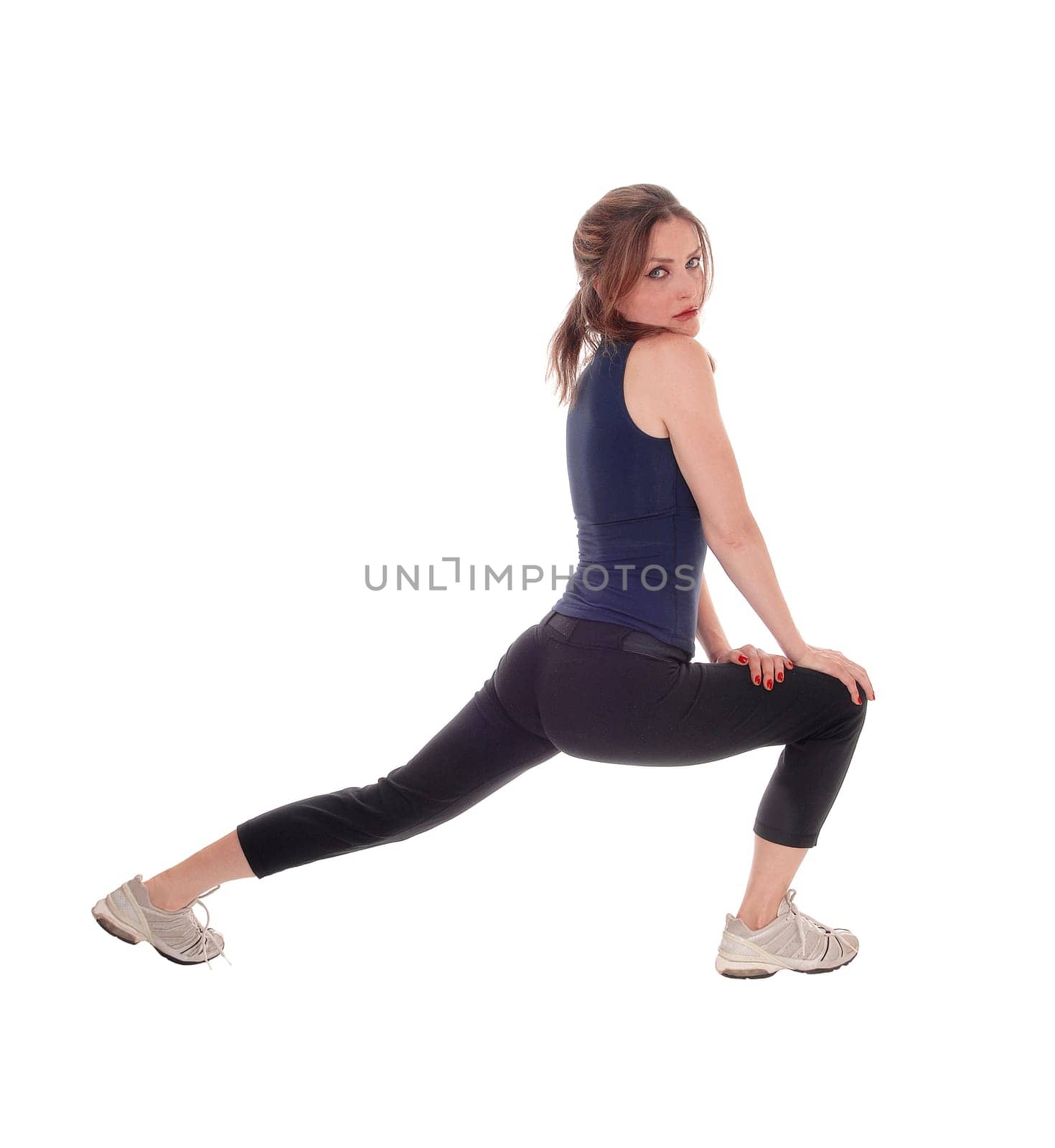 A slim young woman stretching her legs after some exercising, wearing.sportswear, isolated for white background..
