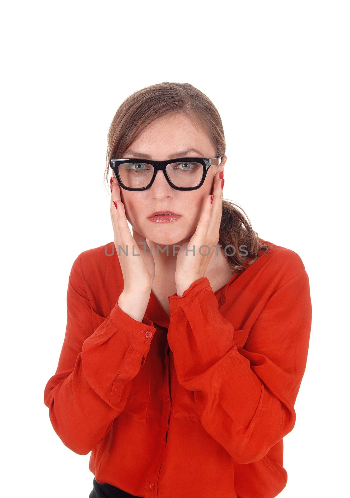 A young afraid looking woman with her hands on her face wearing.black glasses standing isolated for white background..