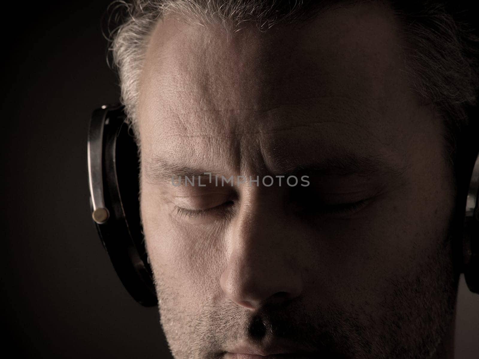 Close up of a man listening music with headphones