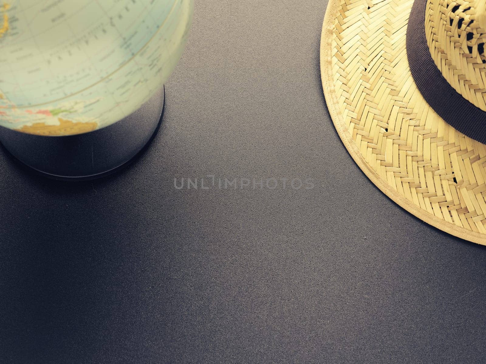 Travel or vacation concept with a straw hat and a retro globe, space for text or image