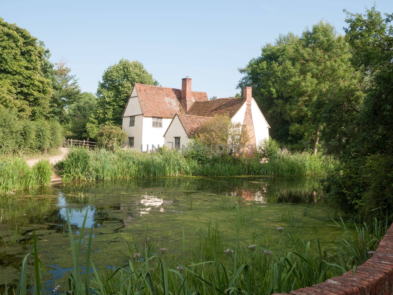 Side view of Willy Lotts' cottage and river front on a clear sunny day  Suffolk  UK