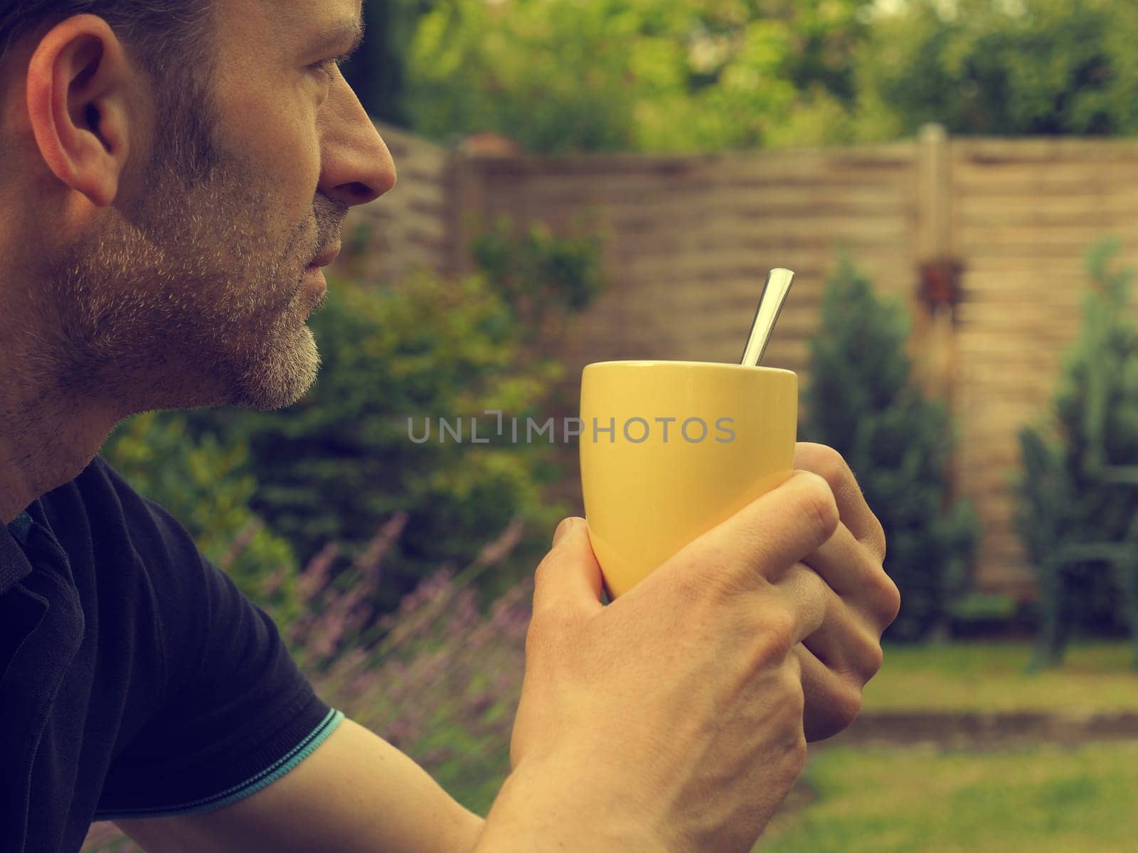Bearded man with a cup of coffee in the garden, have a break concept