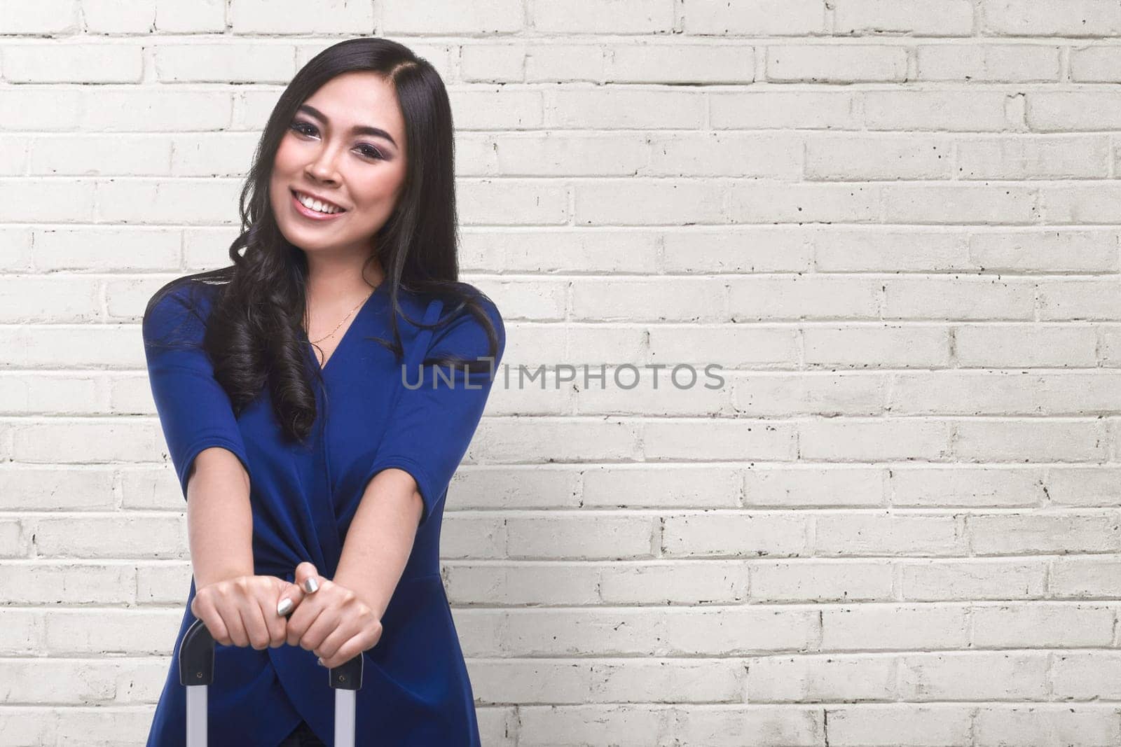 Traveler asian woman with smiley face standing against white wall background