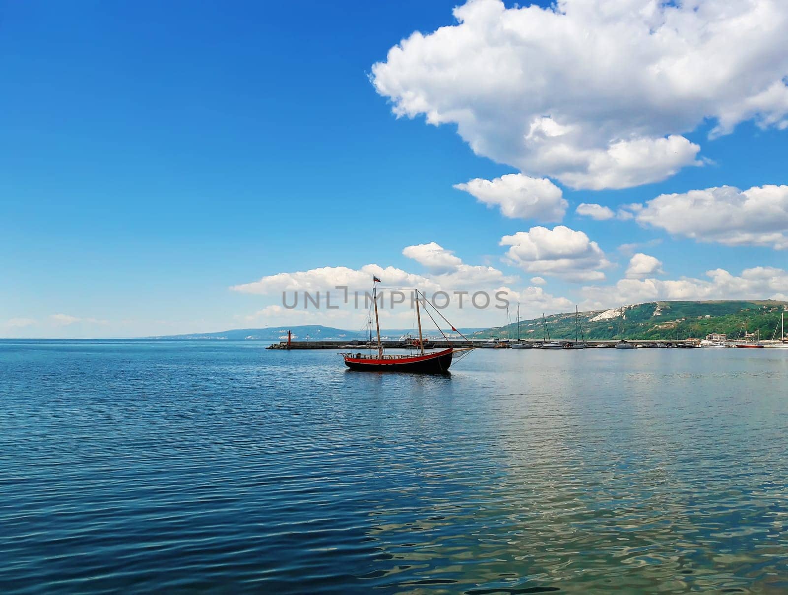 Sail boat floating in the sea near the pear at Balchik city, Bulgaria. Summer vacation background. Joy, happiness and recreation concept