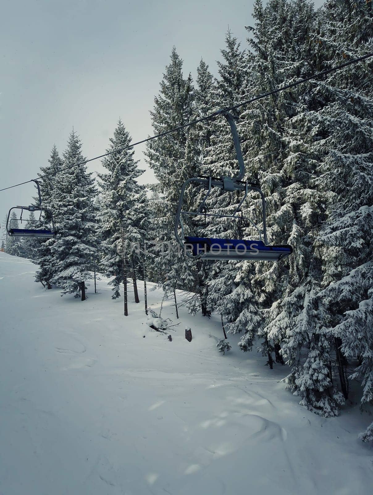 Chair lift at ski resort in sun winter day. Carpathian Mountains, Ukraine.