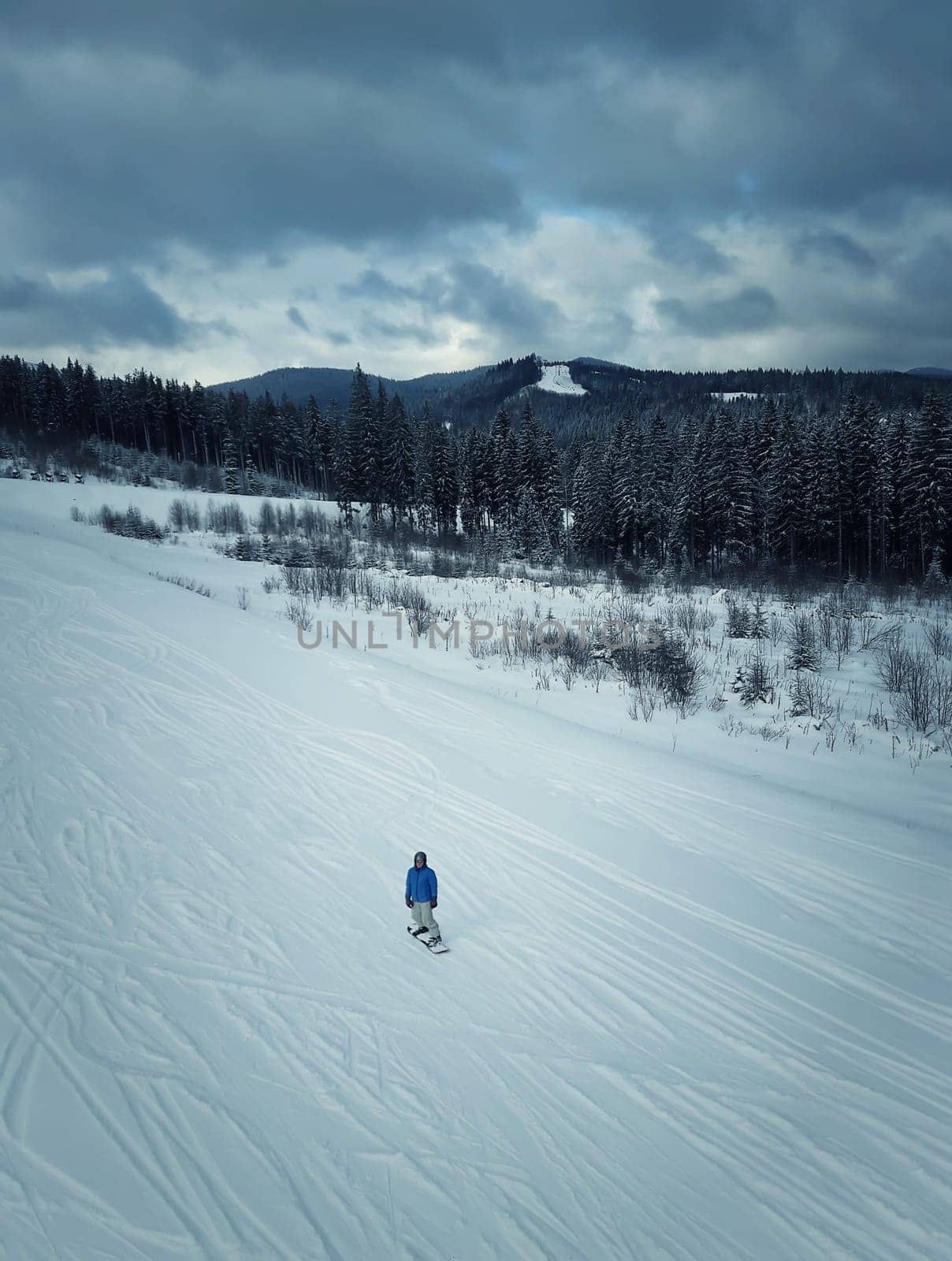 Active man snowboarder riding on a winter mountain slope. Bukovel, Ukraine ski resort.