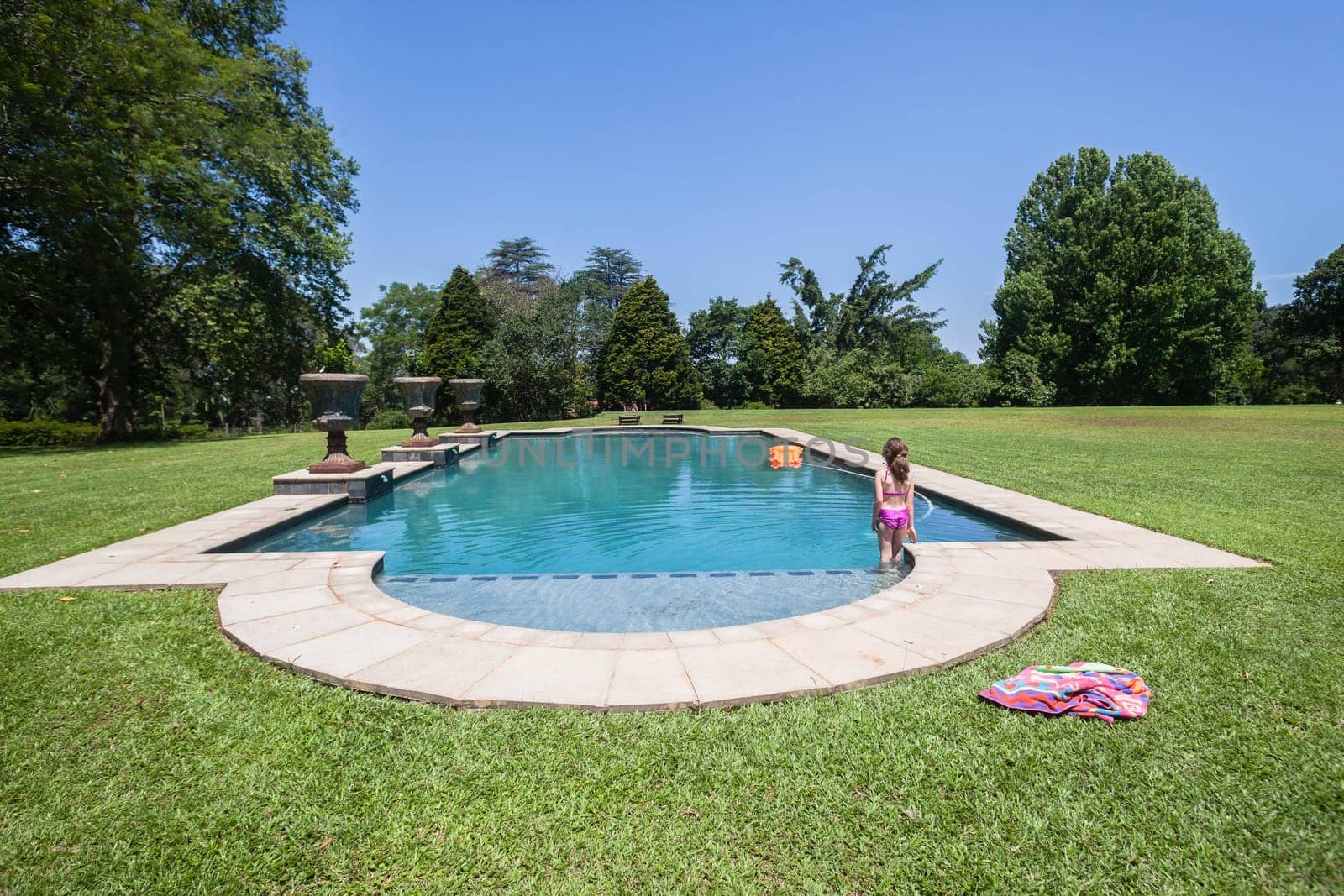 Summer day young girl swimming pool at  private home