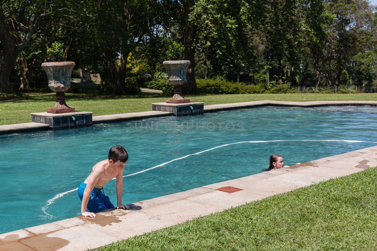 Boys girl swimming pool home summer playtime
