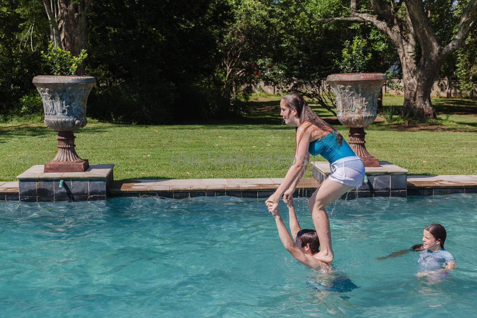 Girl, Boy playing in swimming pool home summer
