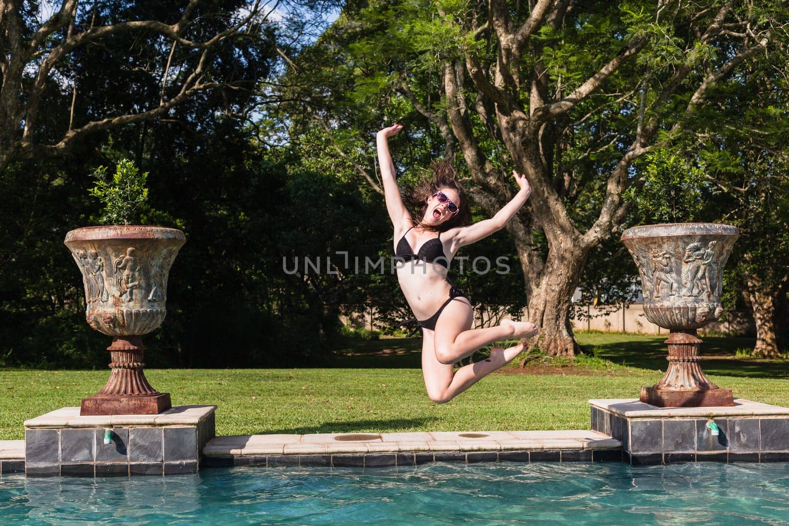 Girl running jumping into home  swimming pool summer playtime
