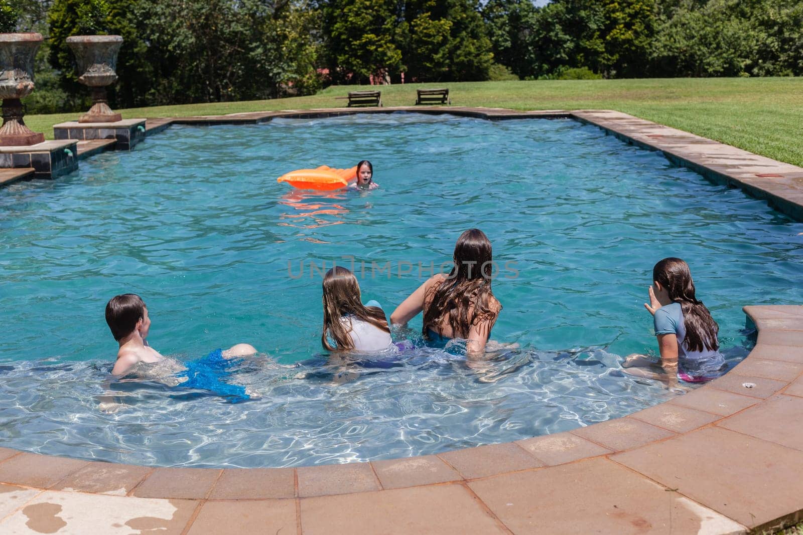 Girl, Boy playing in swimming pool home summer
