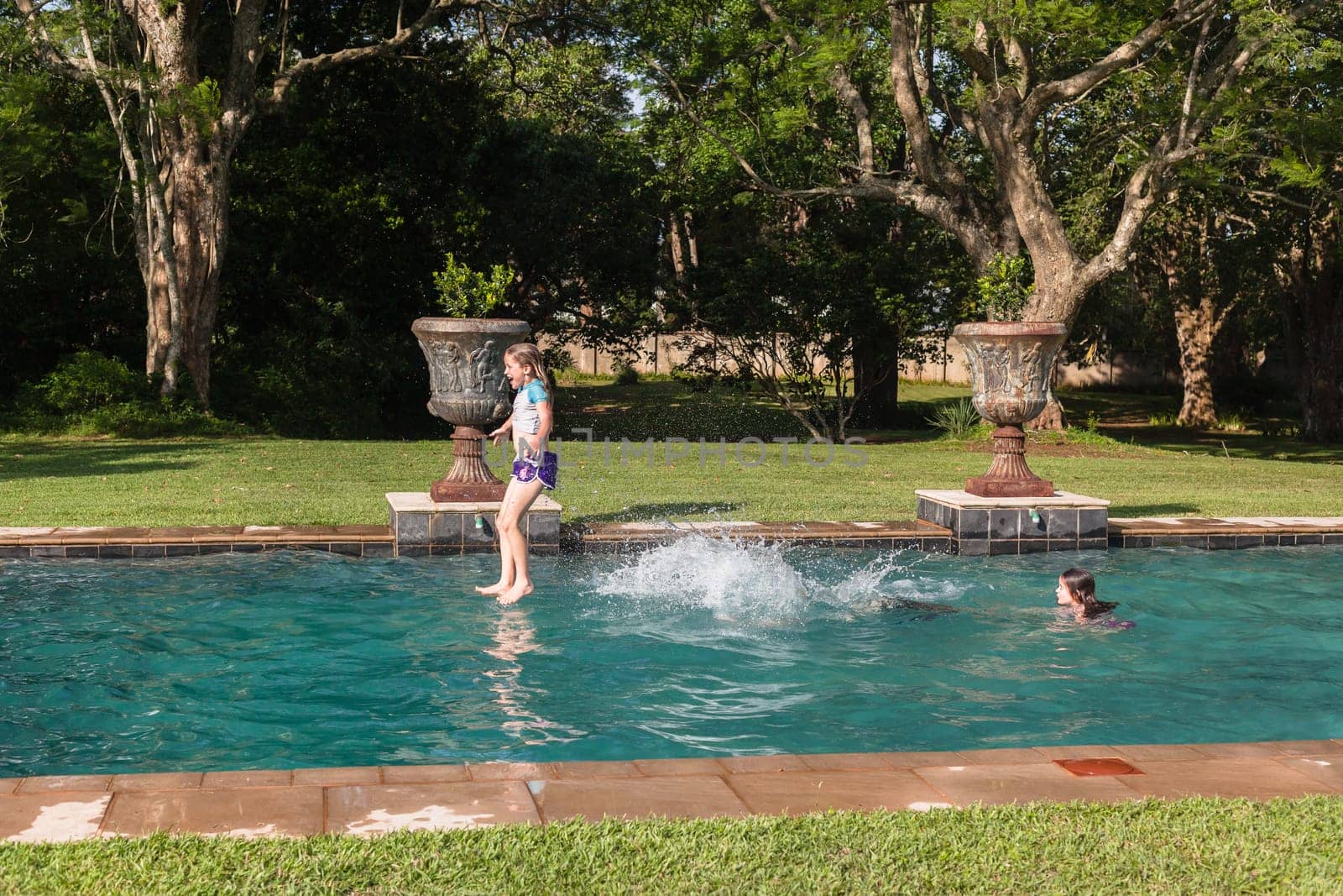 Girl Boy playing in swimming pool home summer