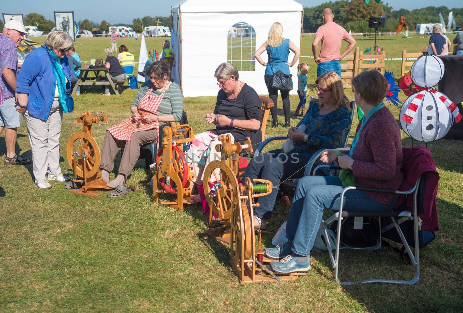 DENEKAMP, NETHERLANDS - SEPTEMBER 25, 2016: elderly women working on wooden spinning wheels during a festival