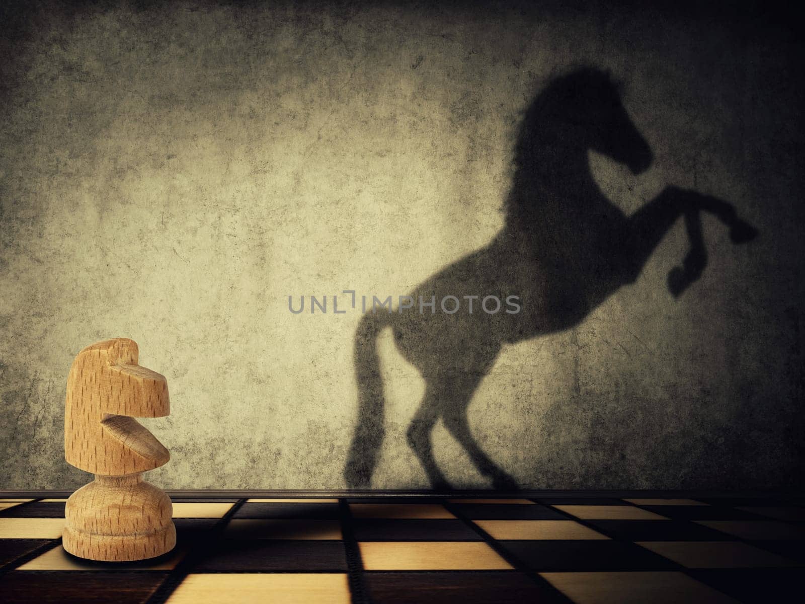 Magical transformation as a wooden knight chess piece casting a shadow of a wild horse on two legs on the wall. Symbol of business aspirations, freedom and leadership concept.