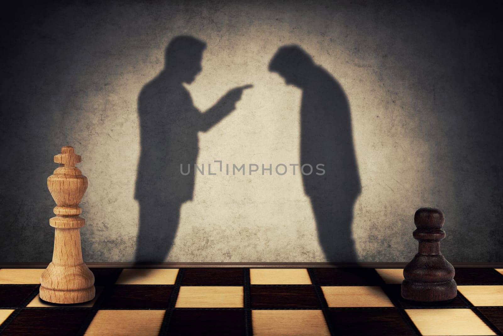 Chess pawn and king standing in front one another with their shadow transform into businessman silhouettes. Business hierarchy misunderstanding concept.