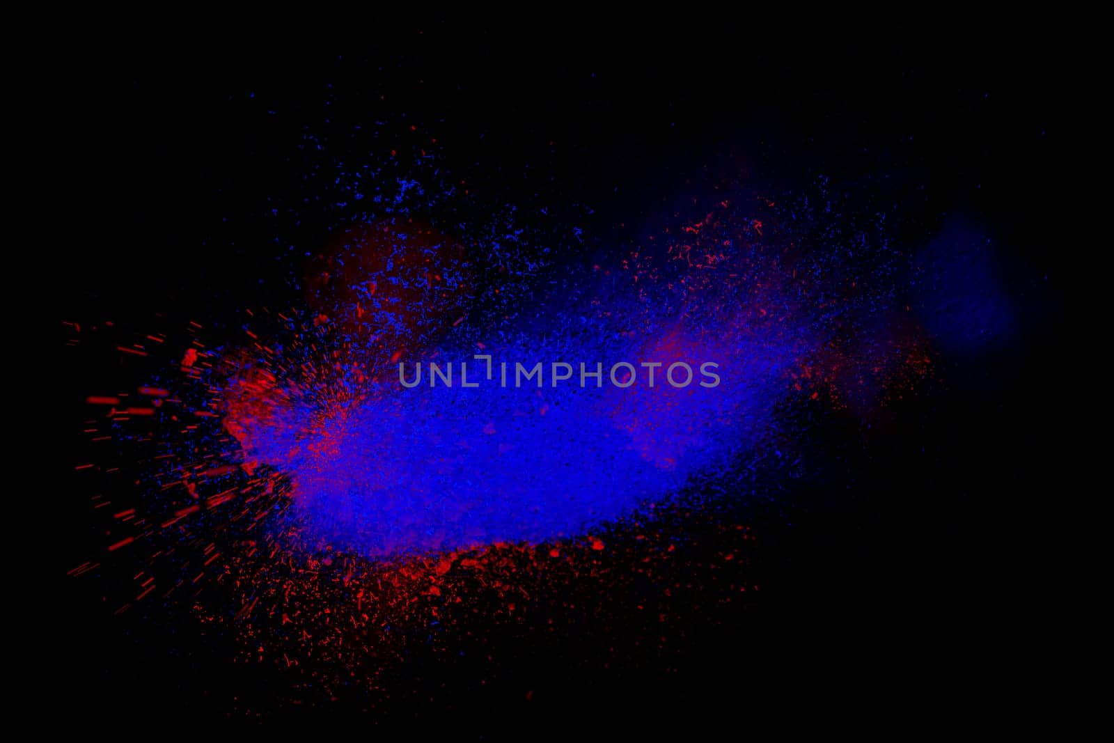 Freeze motion of red and blue powder exploding, isolated on black, dark background. Abstract design of dust cloud. Particles explosion, screen saver wallpaper with copy space. Vivid colorful ash