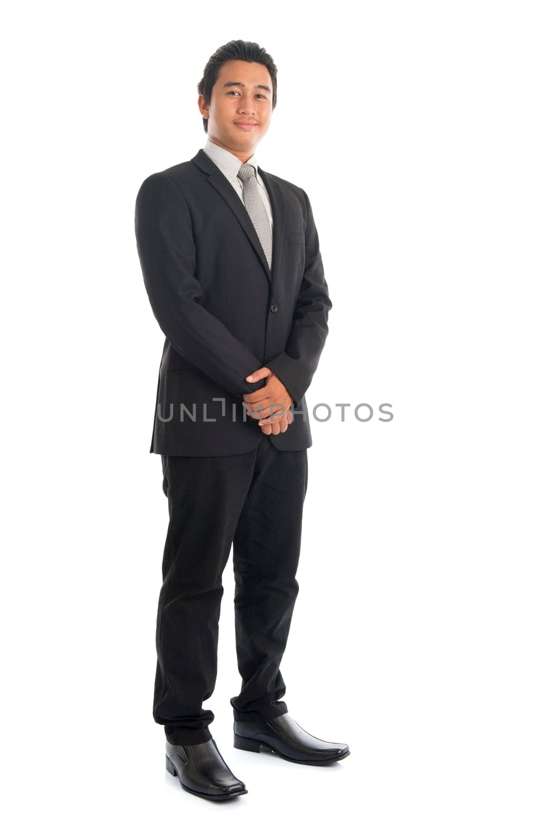 Full body handsome young Southeast Asian businessman standing isolated on white background.