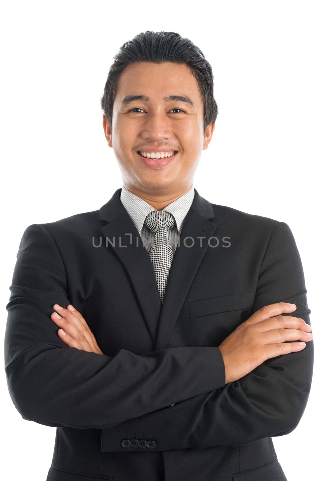 Portrait of attractive arm crossed young Southeast Asian businessman standing isolated on white background.