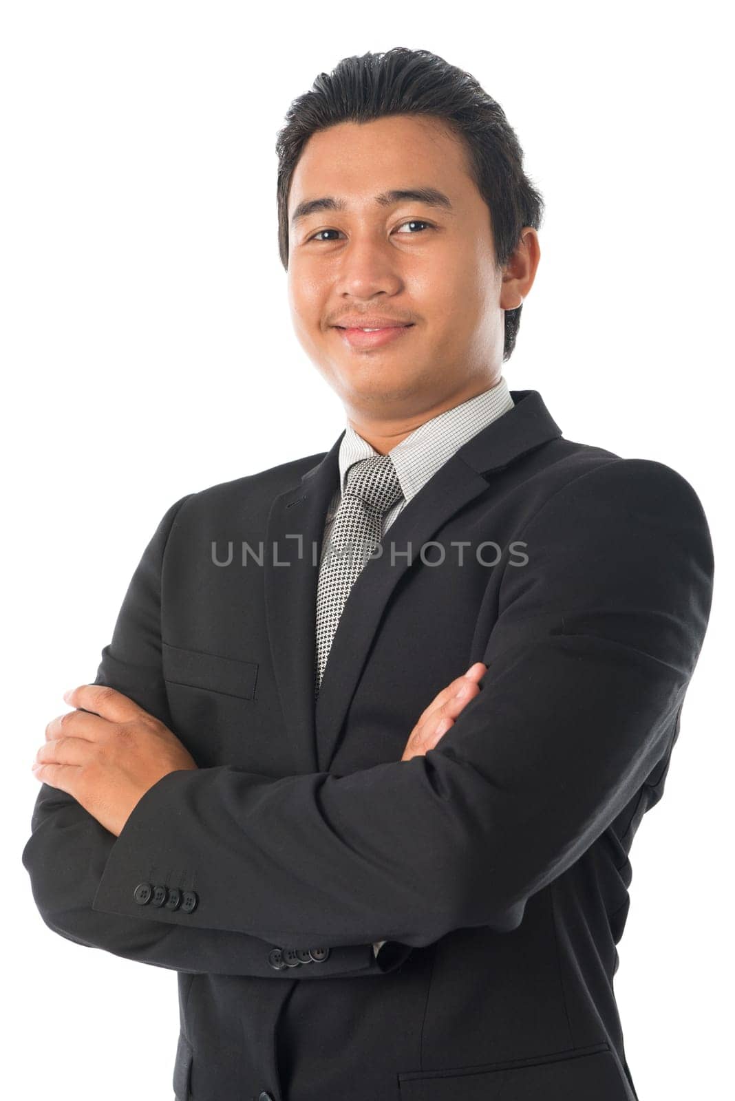 Portrait of arm crossed young Southeast Asian businessman standing isolated on white background.