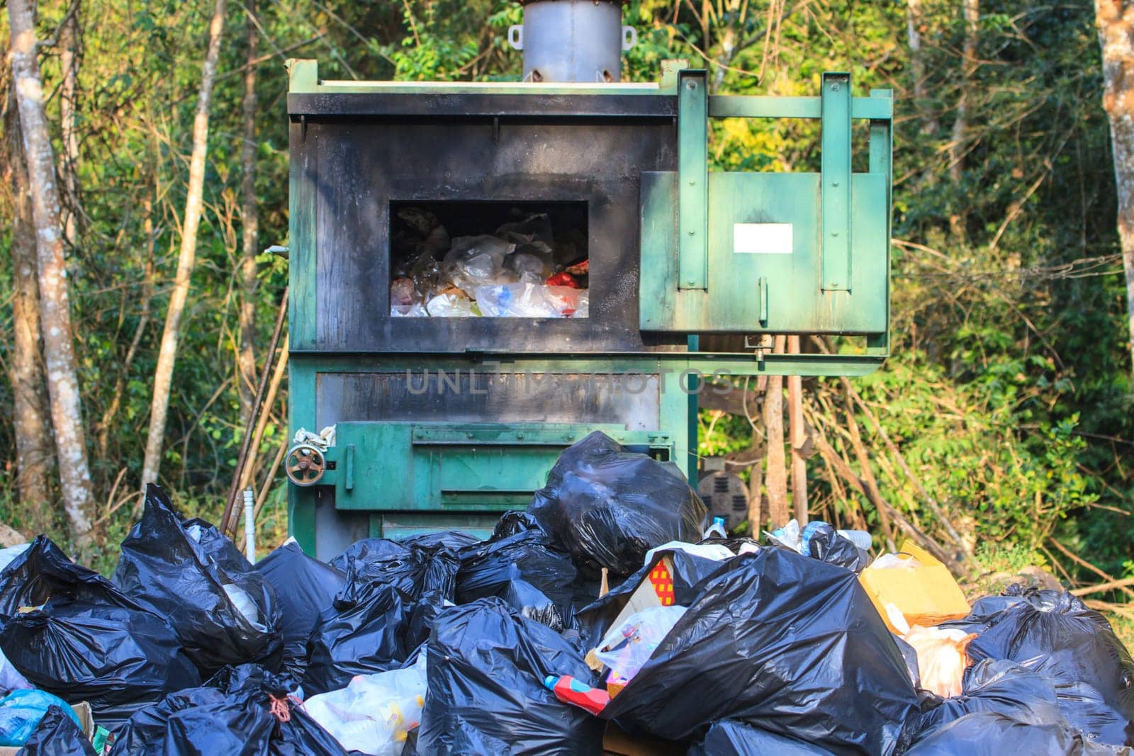 Incinerator in national park with garbage background