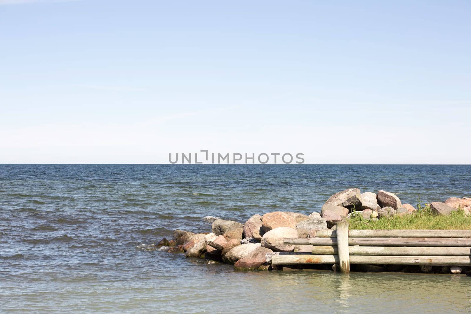 Breakwater with Ocean and a partly cloudy sky.