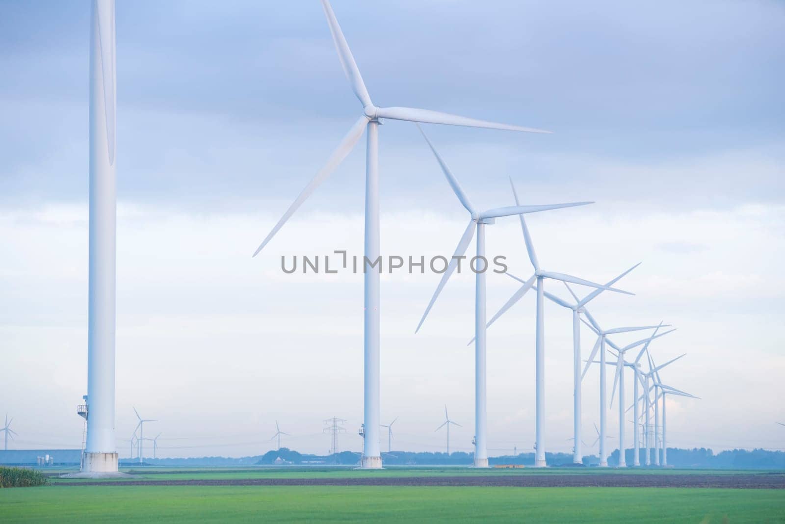 row of wind turbines in early morning in a flat dutch landscape