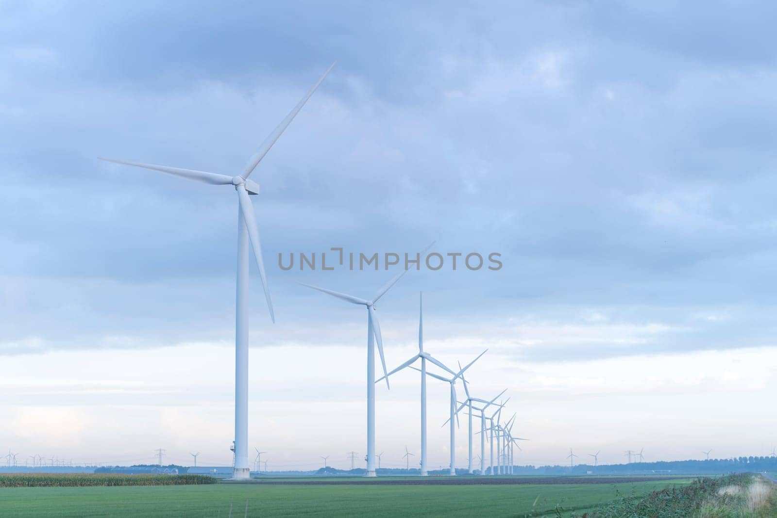 row of wind turbines in early morning in a flat dutch landscape