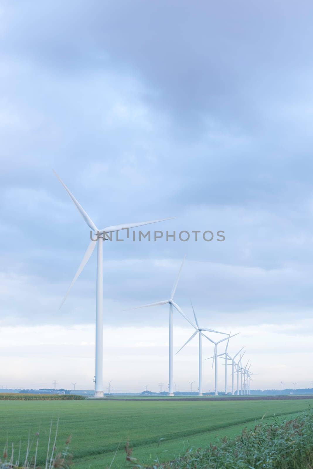 row of wind turbines in early morning in a flat dutch landscape