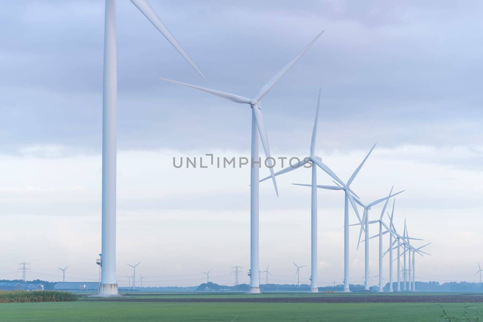 row of wind turbines in early morning in a flat dutch landscape