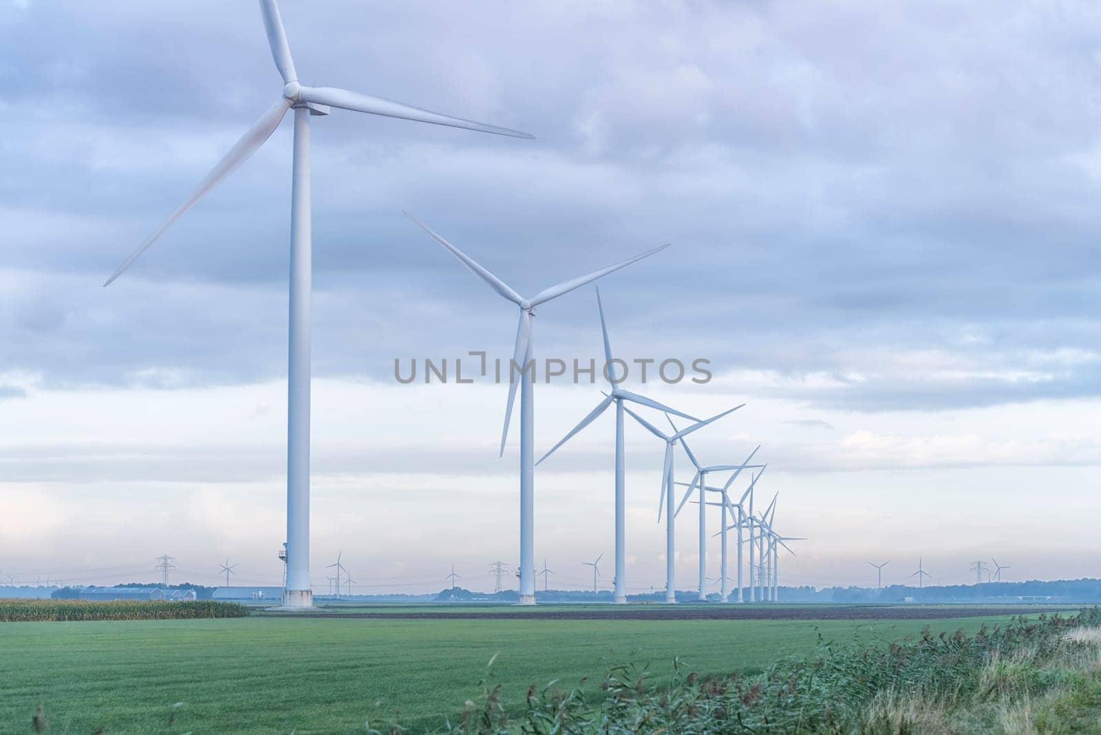 row of wind turbines in early morning in a flat dutch landscape