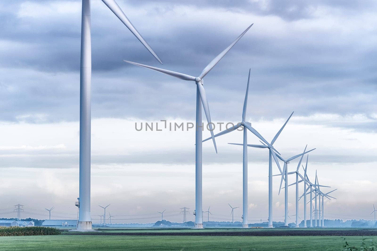 row of wind turbines in early morning in a flat dutch landscape