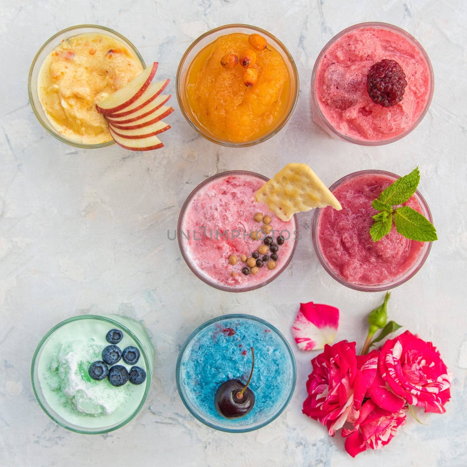 Different smoothie set on a white concrete background