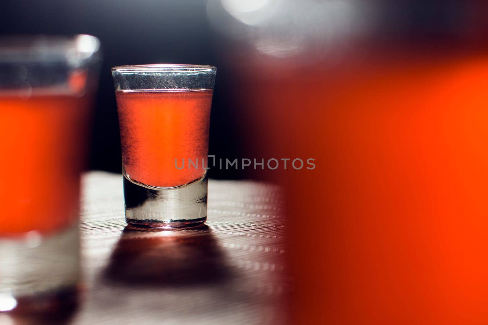 Alcoholic glasses with orange alcoholic drink are on the table. Alcohol addiction concept.