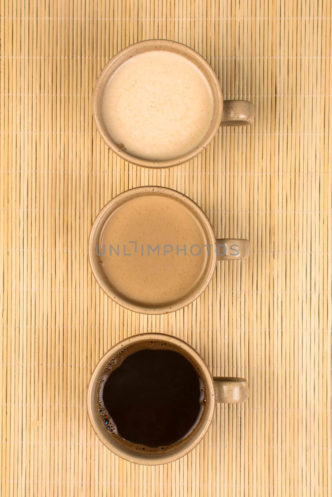 Three cups of different coffee are on natural background.