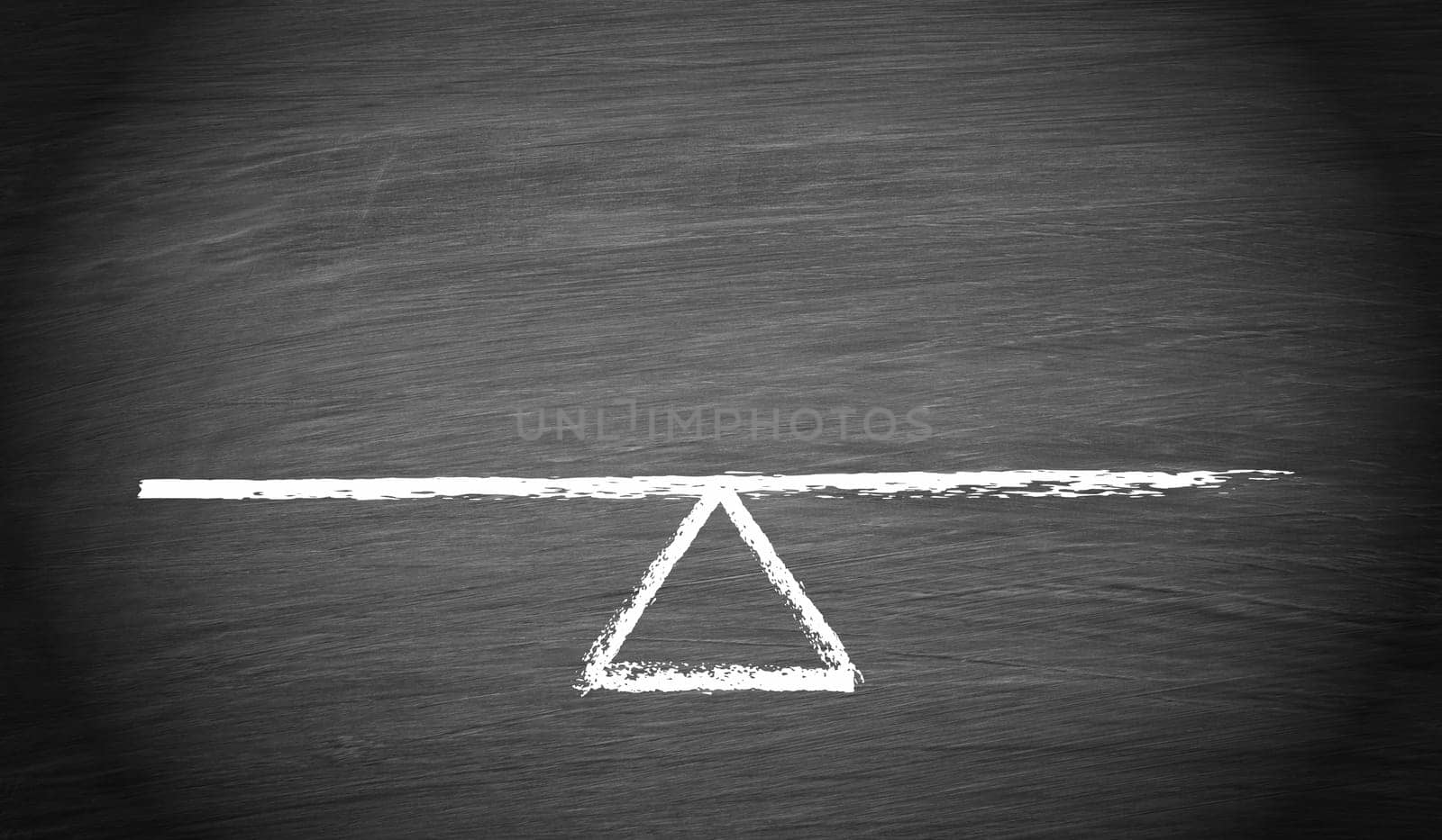 Seesaw or scale in balance on chalkboard background