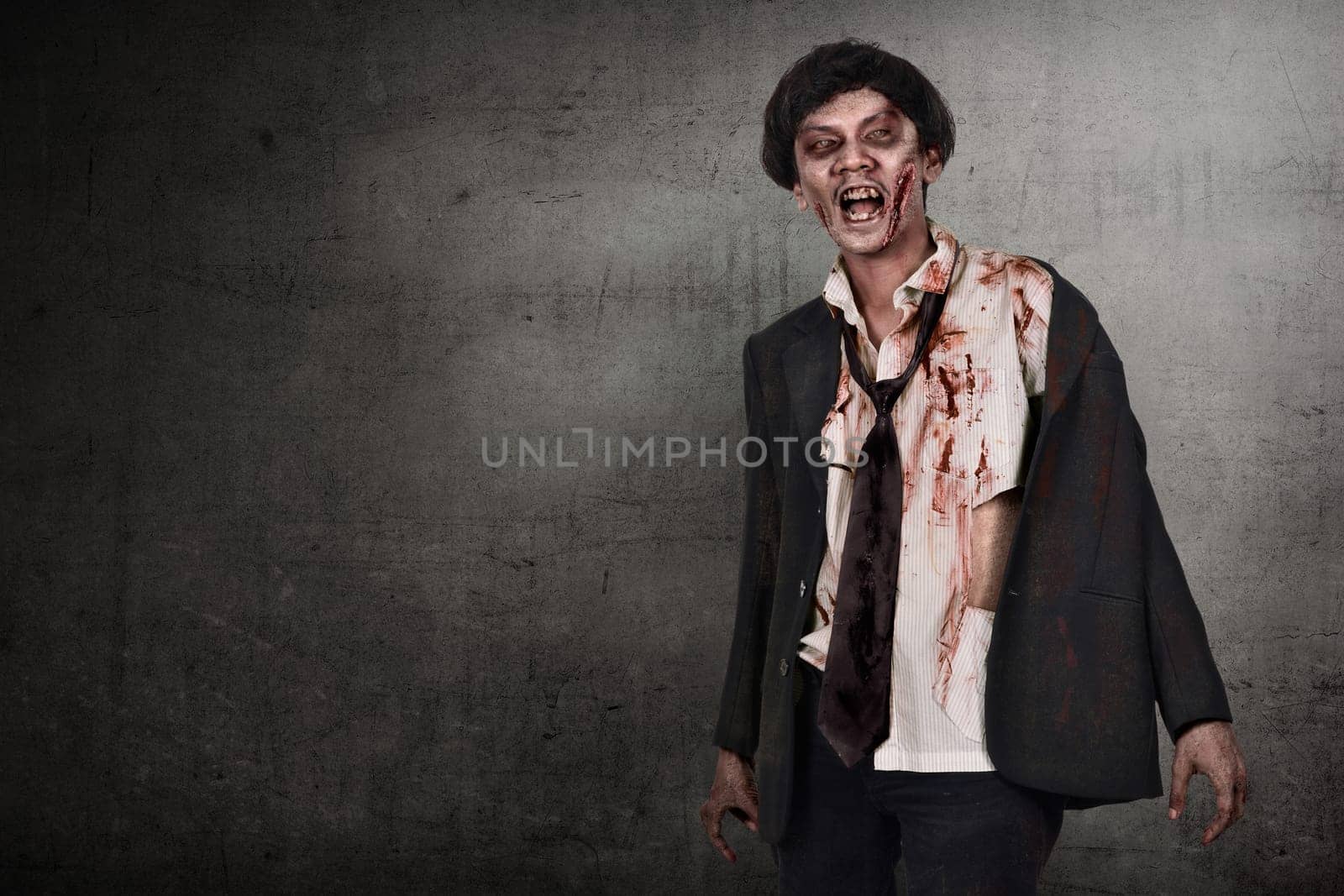 Portrait of asian zombies man with wounded face against dark wall background