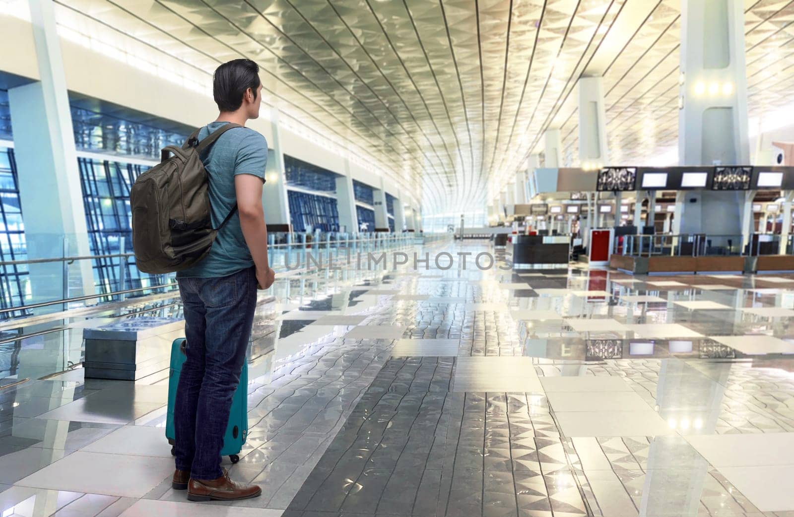 Traveler asian man with luggage waiting plane in the airport terminal