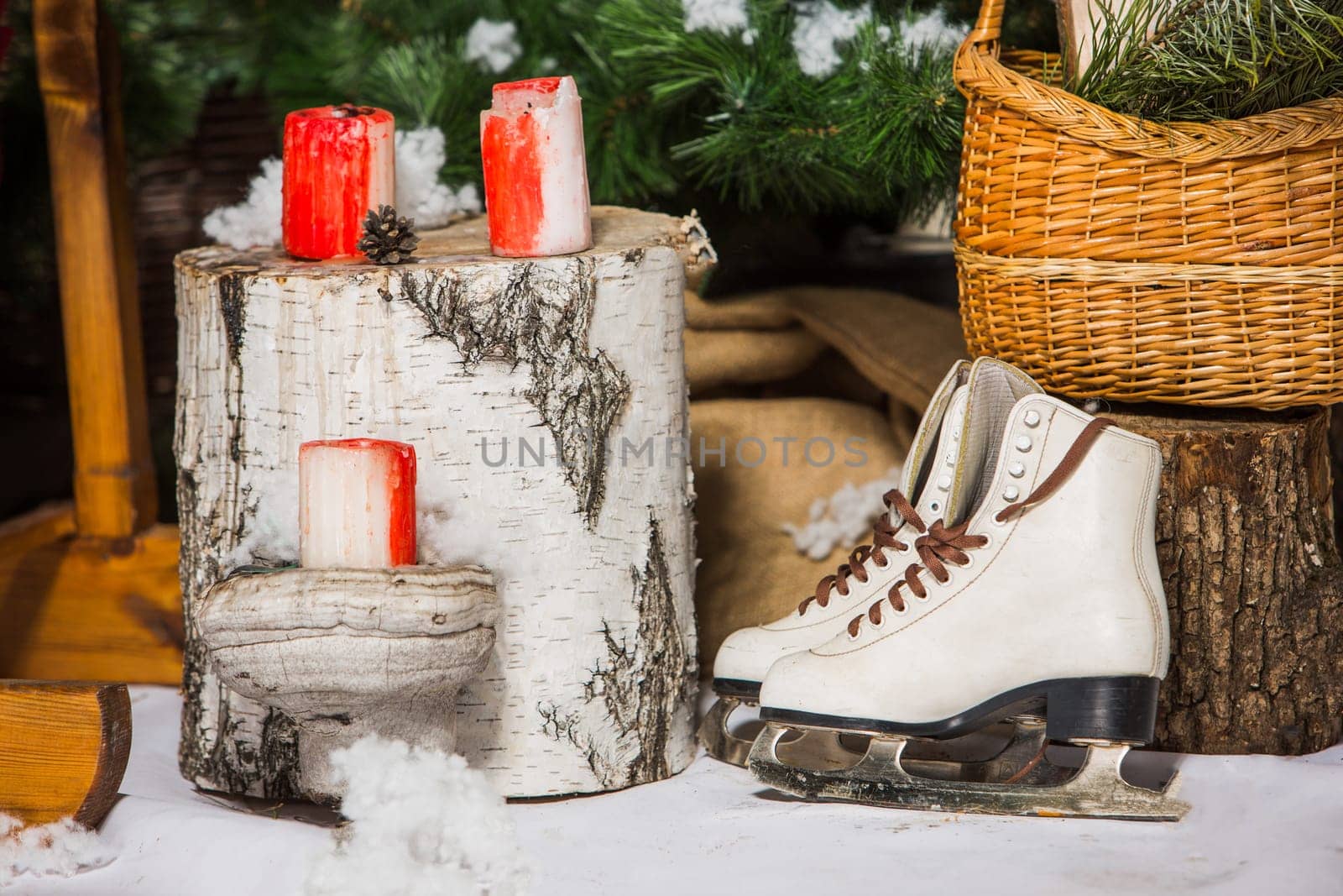 Vintage ice skates for figure skating with fir tree branch hanging on rustic background. Christmas decoration.